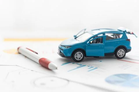Small toy car and wooden toy house close up image on blueprint background. Stock Photos