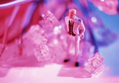 Small toy figure next to computer plugs Stock Photos