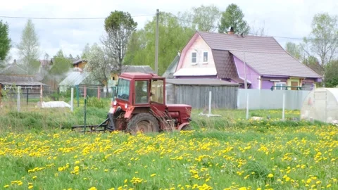 A small tractor rides across the field. Rural landscape Stock Footage 131527490