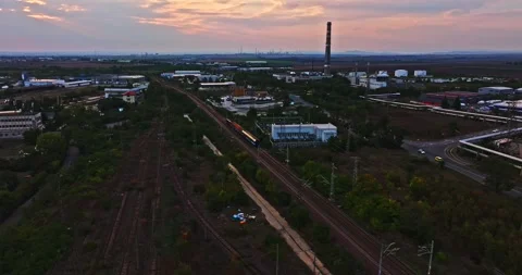 Small Train Composition Exiting Large Megapolis Towards Industrial Area Sunset Video stock 300447747