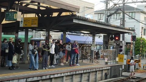 Small train station platform with people waiting for train. Kamakura, Japan. Stock Footage 247134996