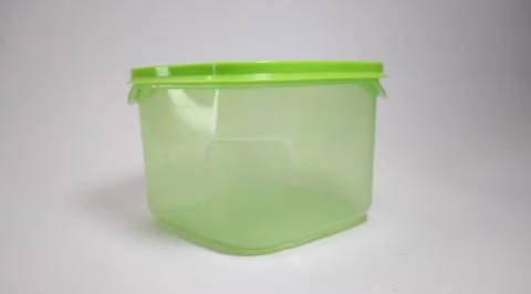 Small transparent green storage box with solid green lid, white background Stock Photos
