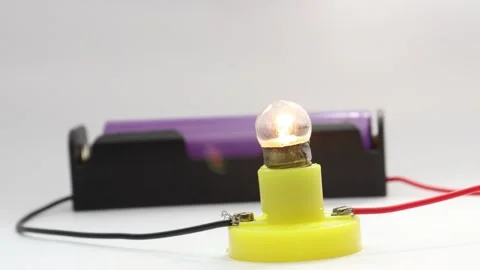 Small transparent light bulb glows when connected to dc power Stock Footage 341538727