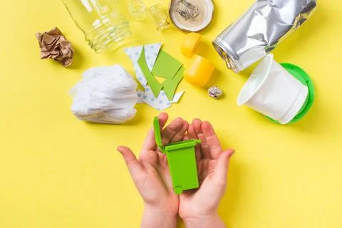 Small trash bin in child hands. Clean trash paper, plastic, metal, glass Stock Photos