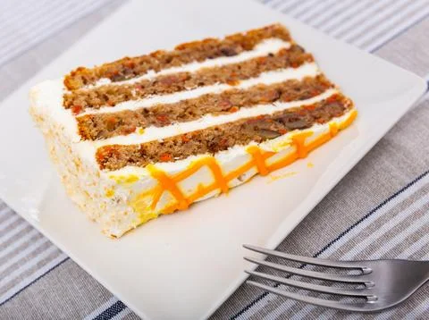 Small triangular piece of carrot cake is on plate 스톡 사진