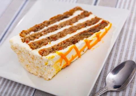 Small triangular piece of carrot cake is on plate 스톡 사진
