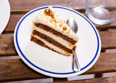 Small triangular piece of carrot cake is on plate Stock Photos