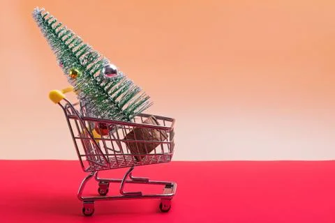 Small trolley with artificial Christmas tree. Stock Photos