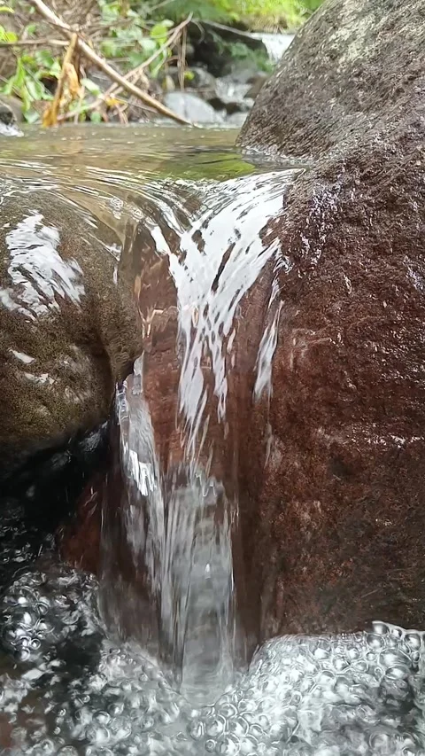 Small Tropical Waterfall Flowing Over Rocks in Forest Stock Footage 329757766