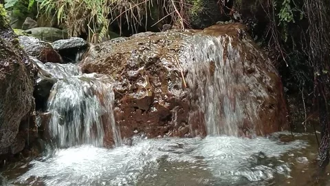 Small Tropical Waterfall Flowing Over Rocks in Forest Stream Stock Footage 329779595