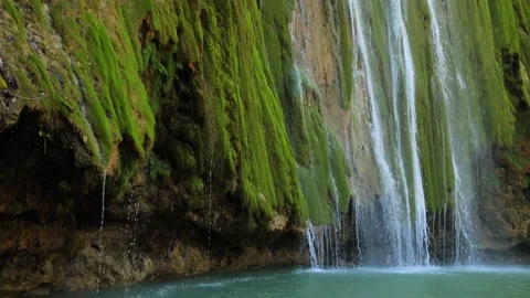 Small tropical waterfall on green soft moss roc falling into the mountain lake. Stock Footage 201914243