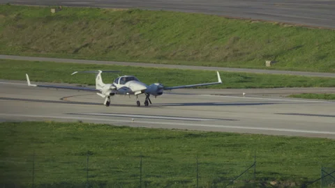 Small twin-engine propeller plane taking off from runway Stock Footage 329775496