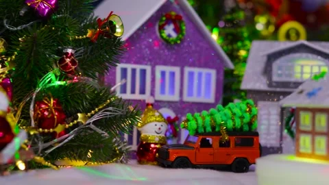 A small two-tone house spins in the center of a Christmas town Stock Footage 319813555