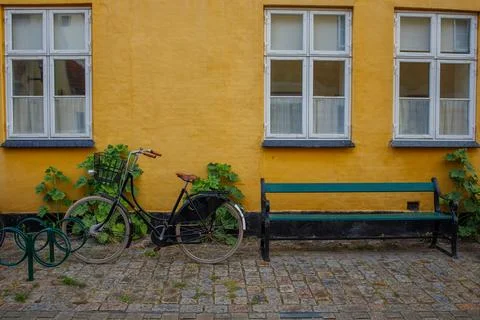 Small typical yellow old danish house in Dragor town. Bike parked near hous.. Stock-Fotos