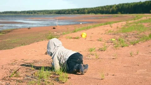 Small unrecognizable kid exploring world on sea beach. Baby crawls on nature Stock Footage 123611830