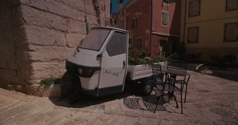 Small utility vehicle parked on stone square Vídeo Stock 334103483