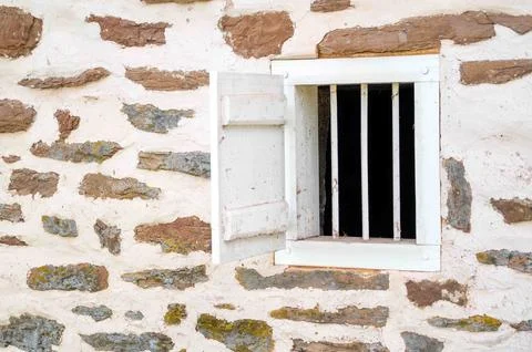 Small ventilation window with bars and shutter colonial farm building Stock Photos