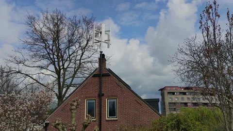 Small vertical axis wind turbine for homes mounted on the house facade rotating Stock Footage 175950317