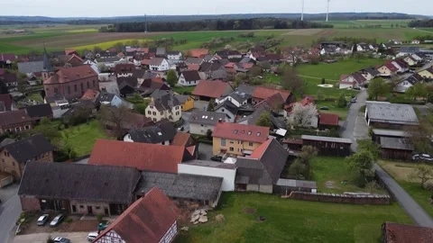 Small village with a church in the background of wind turbines Stock Footage 154369727