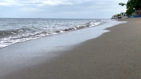 Small warm waves on the sandy shore of the sea gently stroke the shore Stock Footage 238578750
