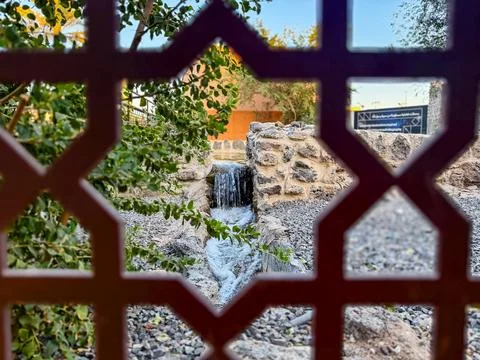 Small Water Cascade Viewed Through Decorative Arabian Pattern Screen Stock Photos