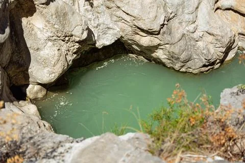 Small water source between rocks exposed to the sun Stock Photos