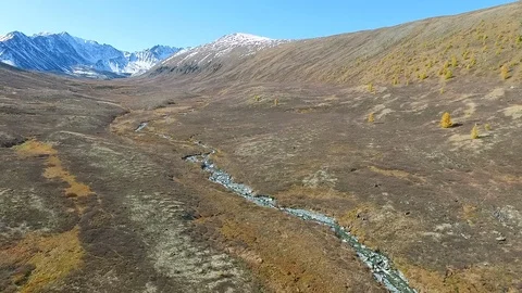 Small water stream flows from pictorial large mountains Stock Footage 116711539