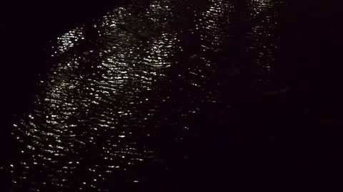 Small water wave in dark night, with white lighting reflection Stock Footage 82331528