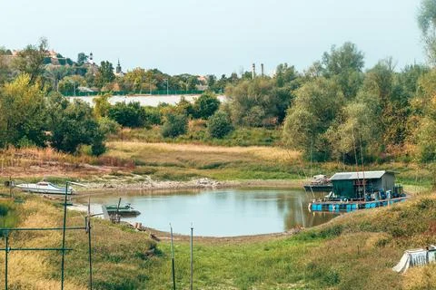 Small watercraft and floating structure in a severely receded river inlet. .. Fotos Stock