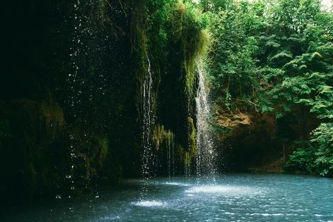 A small waterfall and a lake surrounded by trees in the summer. Wonderful lan Stock-Fotos