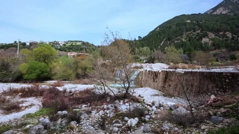 Small Waterfall and River Flowing Near a Village in Autumn Stock Footage 305236079