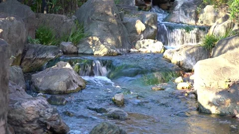 Small waterfall and stream flowing through a rocky landscape. Serene natura.. Stock-Footage 331452856