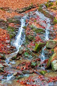 Small waterfall in the autumn forest Stock Photos