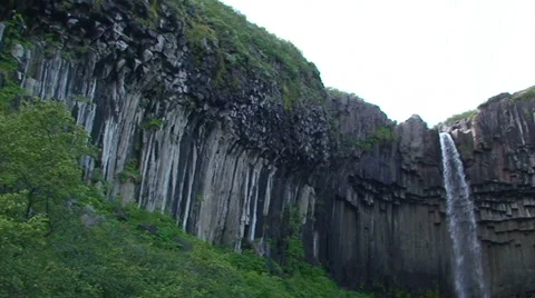 Small waterfall on basaltic volcanic rock hexagonal columns, pan right Video stock 37986651