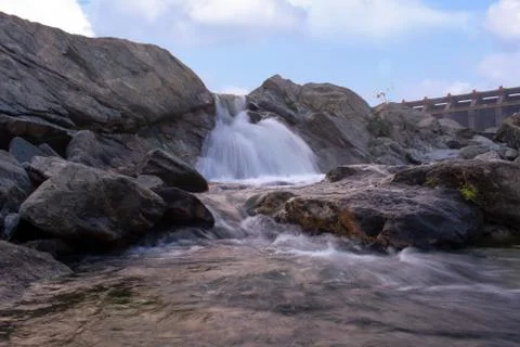 A small waterfall with beautiful clouds in the background Stock Photos