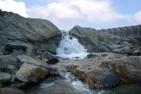 A small waterfall with beautiful clouds in the background Foto stock