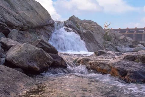 A small waterfall with beautiful clouds captured during sunset Stock Photos