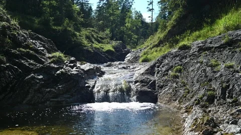 A small waterfall from a beautiful mountain stream in a forest Video stock 219651133