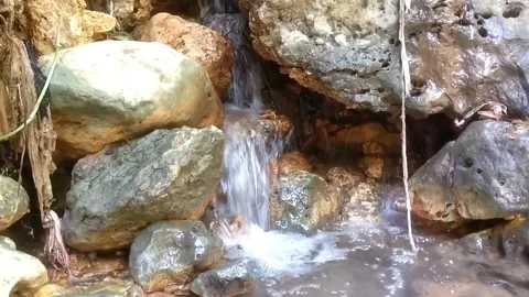 Small waterfall behind the rocks Stockbeeldmateriaal 332916251