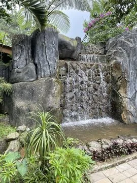 The small waterfall beside the path is made of natural stone Stock Photos