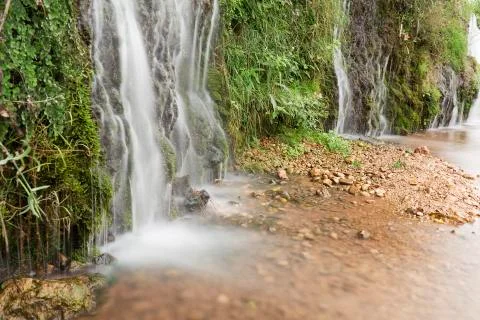 Small waterfall beside the river Stock Photos