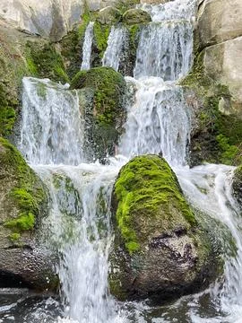 Small waterfall between rocks with green moss Foto stock