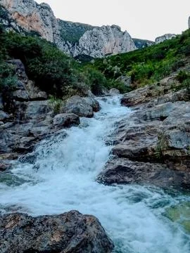 Small waterfall at the bottom of the mountain Stock Photos