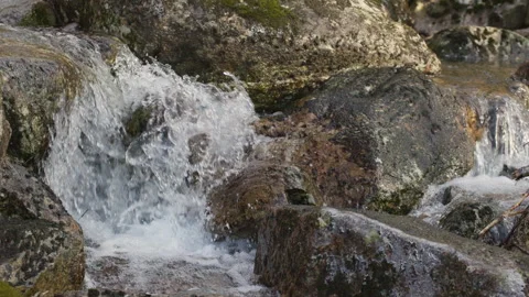 Small Waterfall Cascading Down Rocky Terrain. Stock Footage 332136143