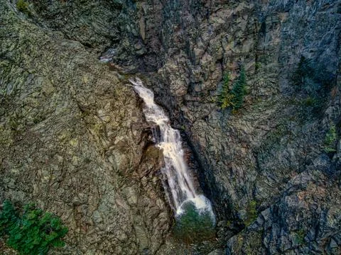 Small Waterfall Cascading Down Rocky Cliff Foto stock