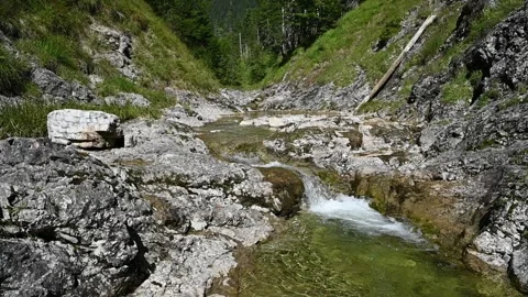 A small waterfall from a cascading mountain stream in the alps (slow motion) Video stock 260845833
