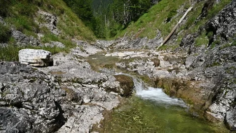 A small waterfall from a cascading mountain stream in the alps Video stock 260845844