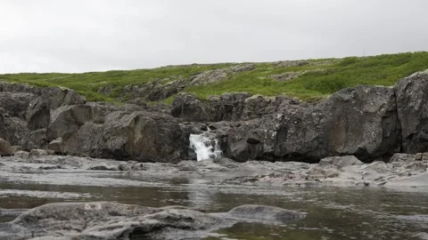 Small Waterfall Cascading Over Rocky Terrain in Iceland 4K Nature Footage Stock Footage 339744200