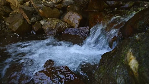 Small Waterfall Cascading Over Wet Rocks in Stream Stock Footage 345712832