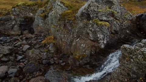 Small Waterfall Cascading Through a Rocky, Mossy Landscape in Iceland Stock Footage 320510456
